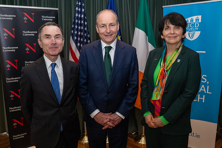 Three people standing, two men and one woman